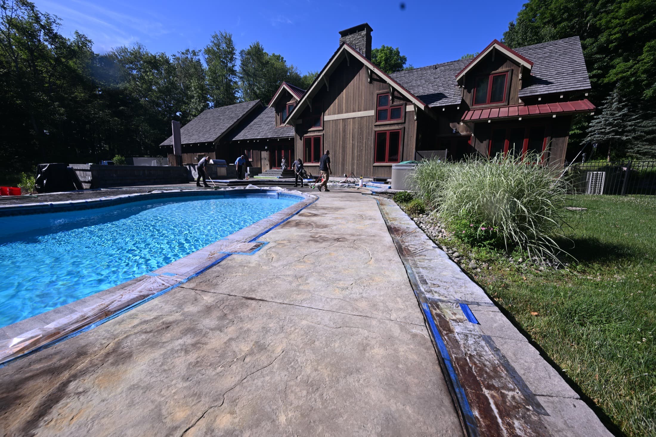 Pool deck concrete masked off and prepped for acid stain treatment in Crawford, NY