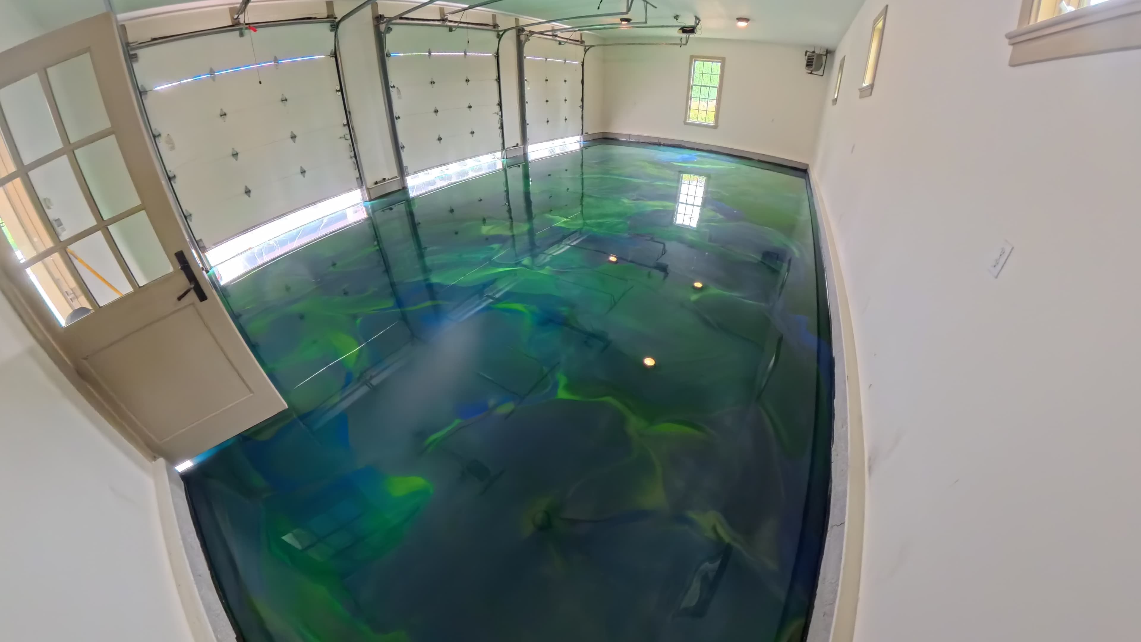 Flowing blue and green metallic epoxy design in a garage converted into a wedding reception venue in Amenia, NY
