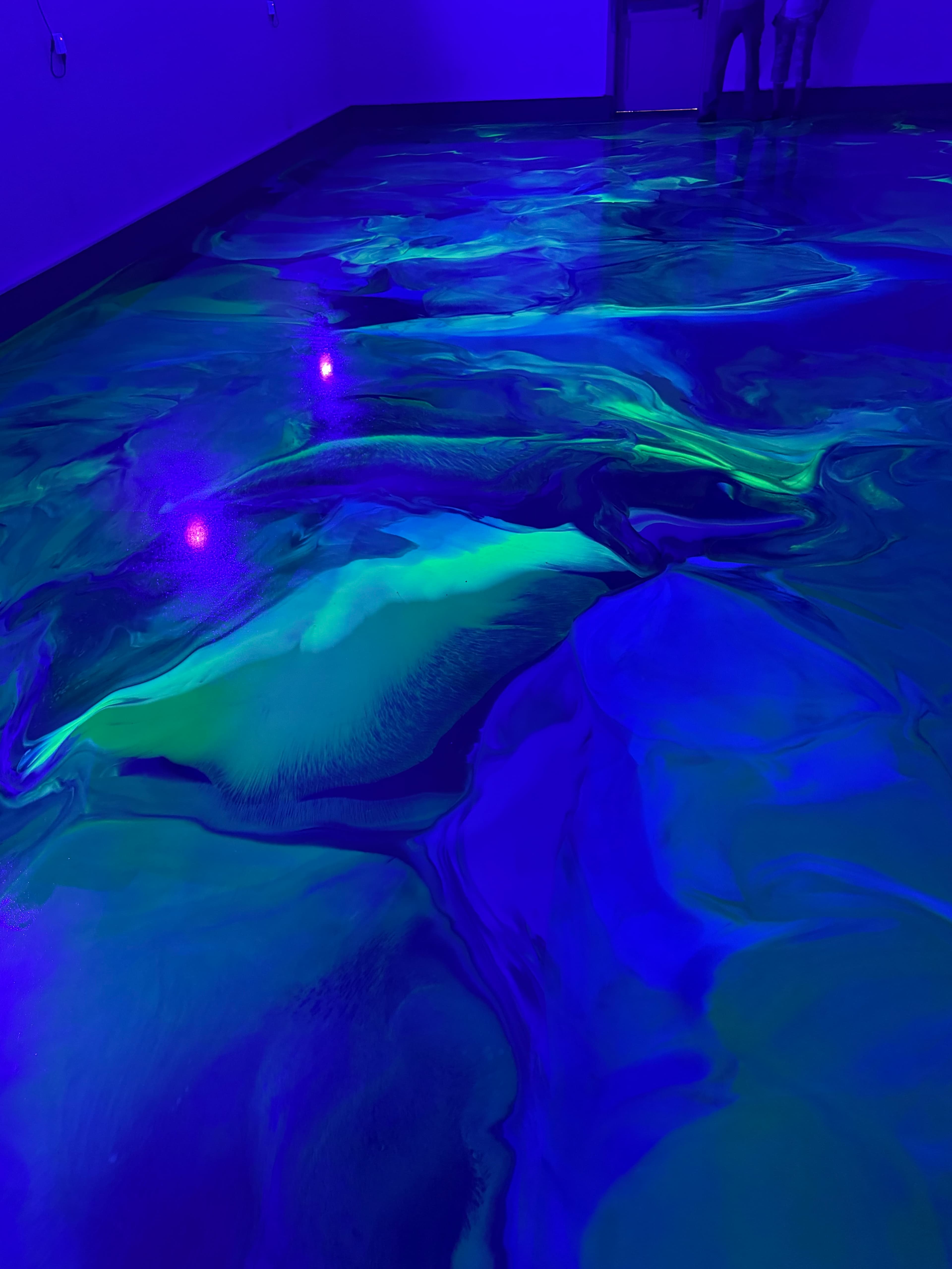 Close-up of the glow-in-the-dark UV additive in a blue and green epoxy floor in Amenia, NY