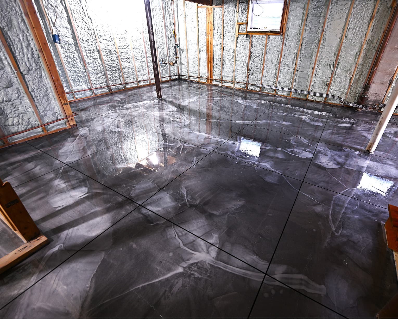 Finished basement floor with a custom swirl-pattern epoxy overlay in Poughkeepsie, NY