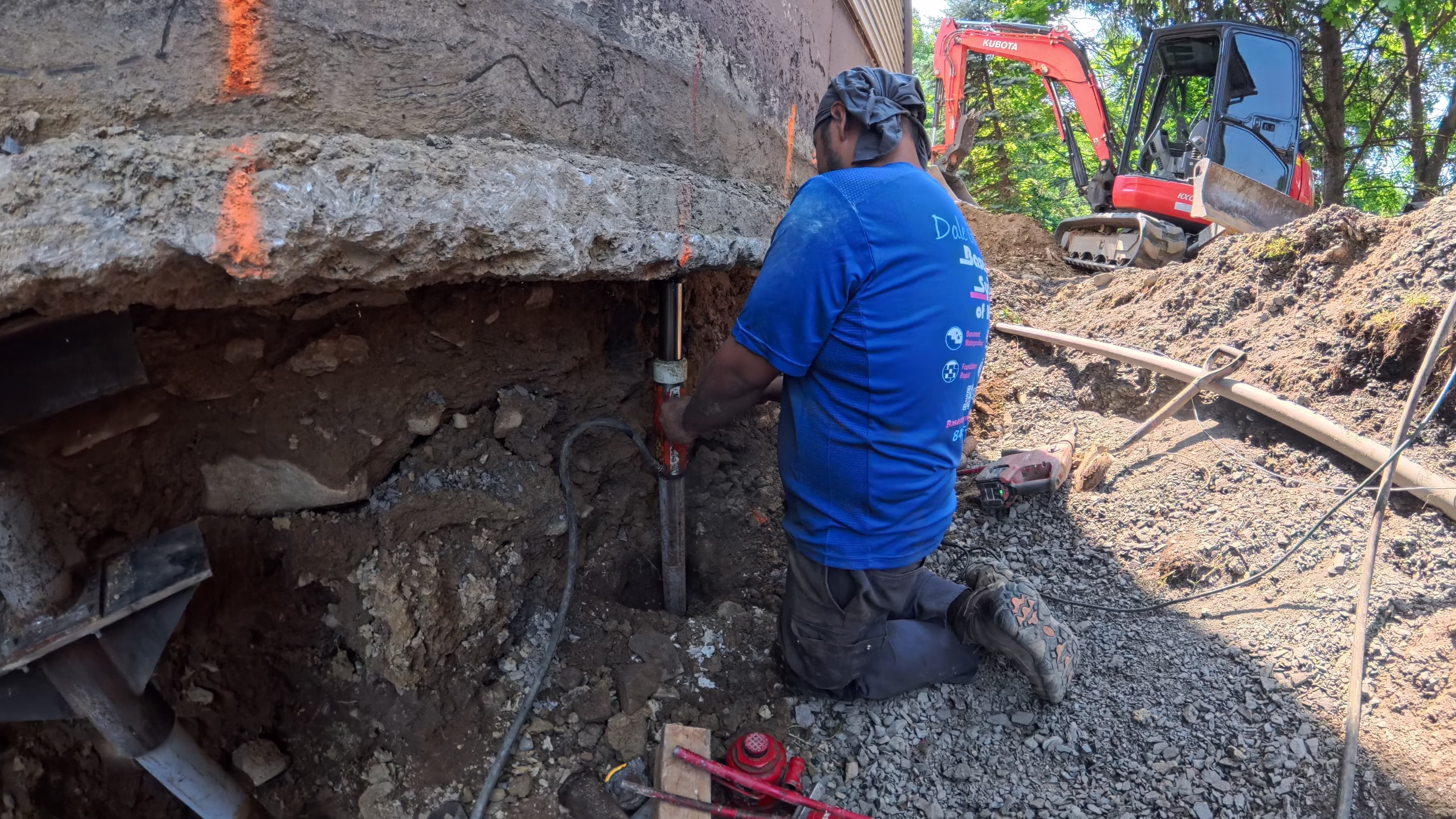 Crew driving a Stabil-Loc push pier beneath the garage footing in Washingtonville, NY