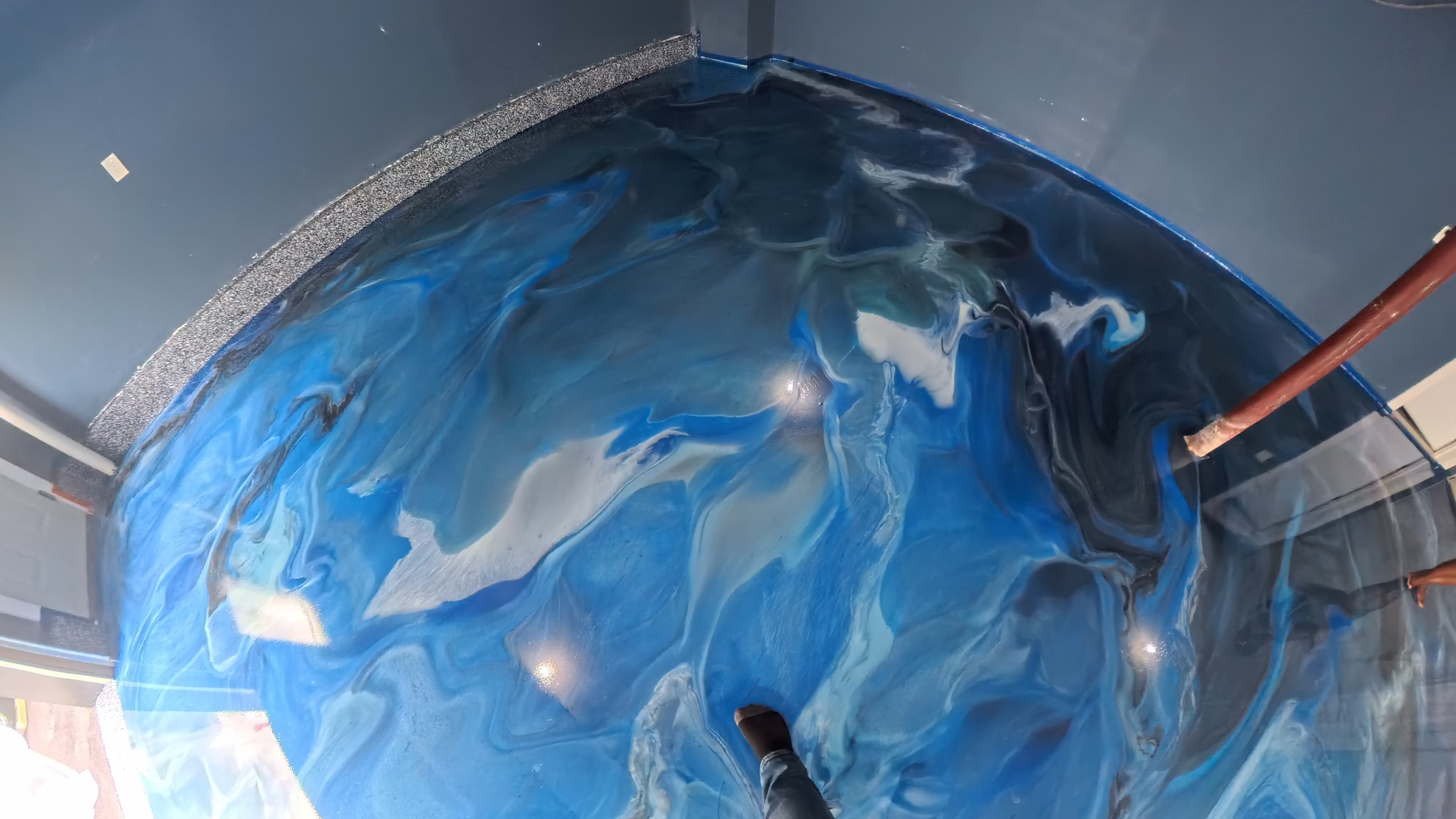 Blue and white metallic swirl epoxy with a flake epoxy border in a Wallkill, NY garage