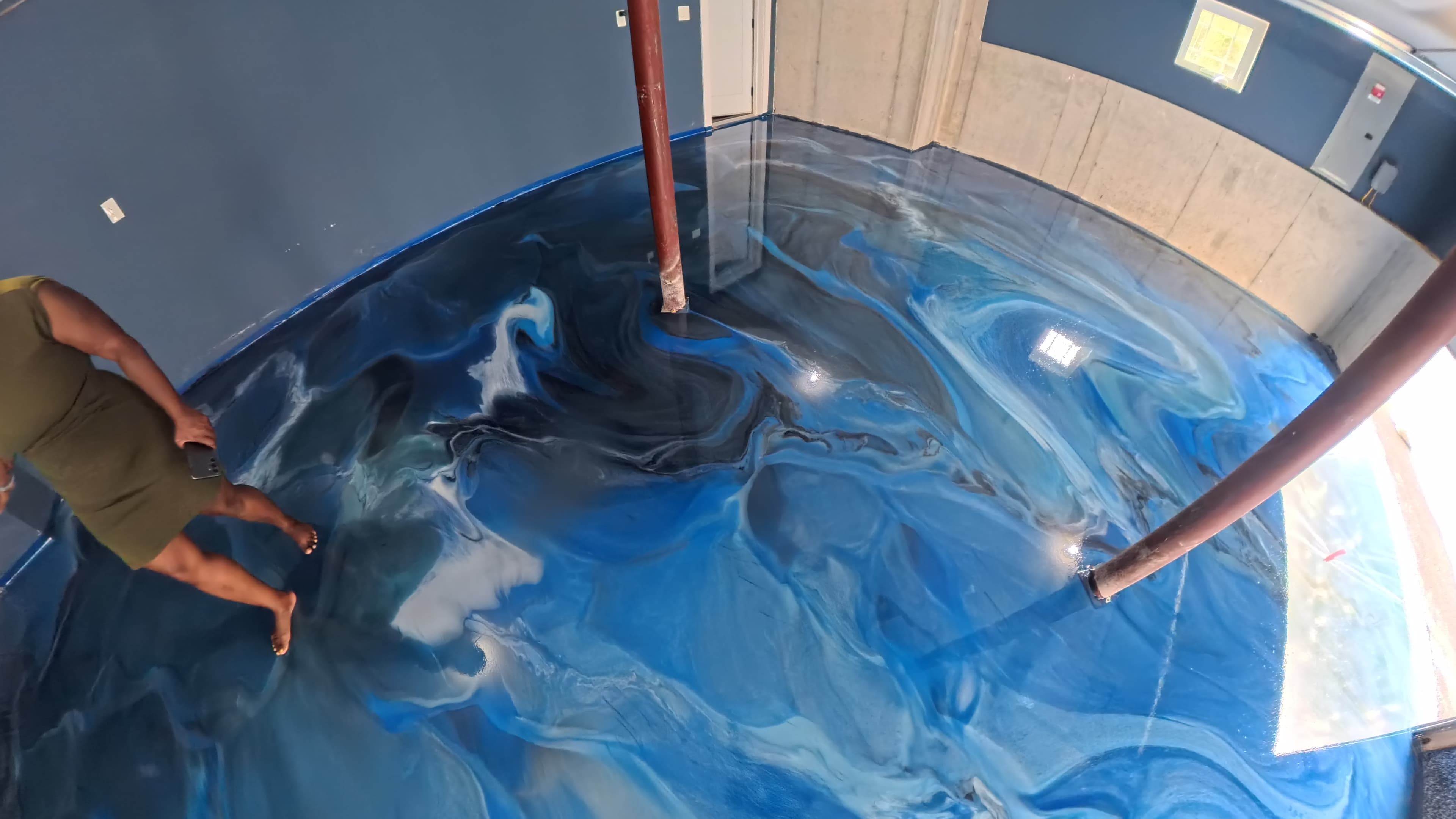 Homeowner walking on the new blue metallic epoxy garage floor in Wallkill, NY