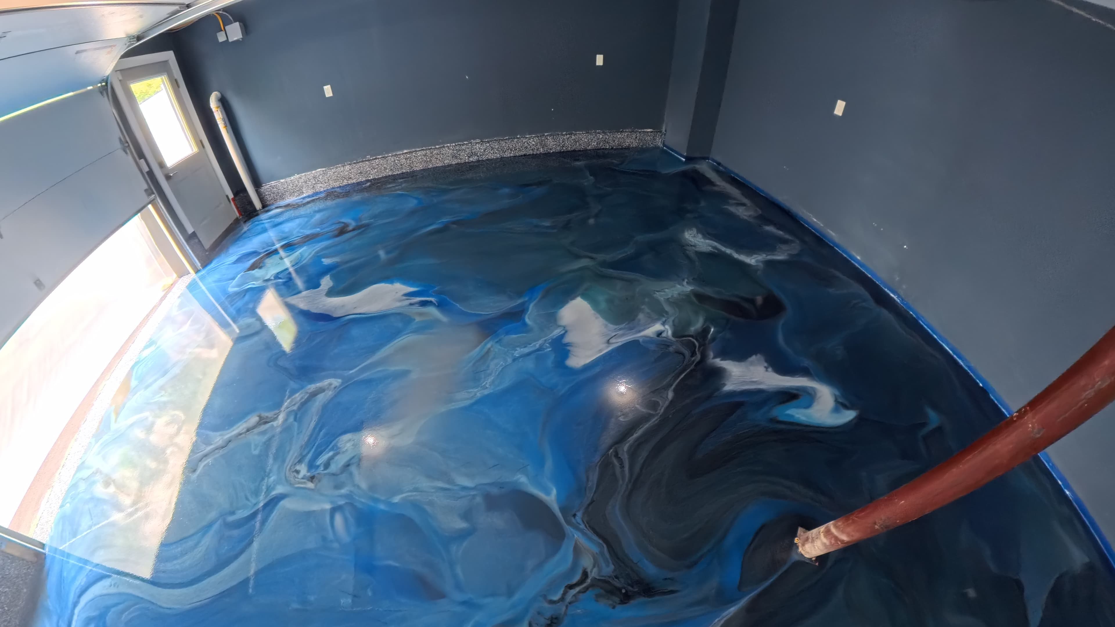 Deep blue metallic epoxy garage floor ready for a home movie theater in Wallkill, NY