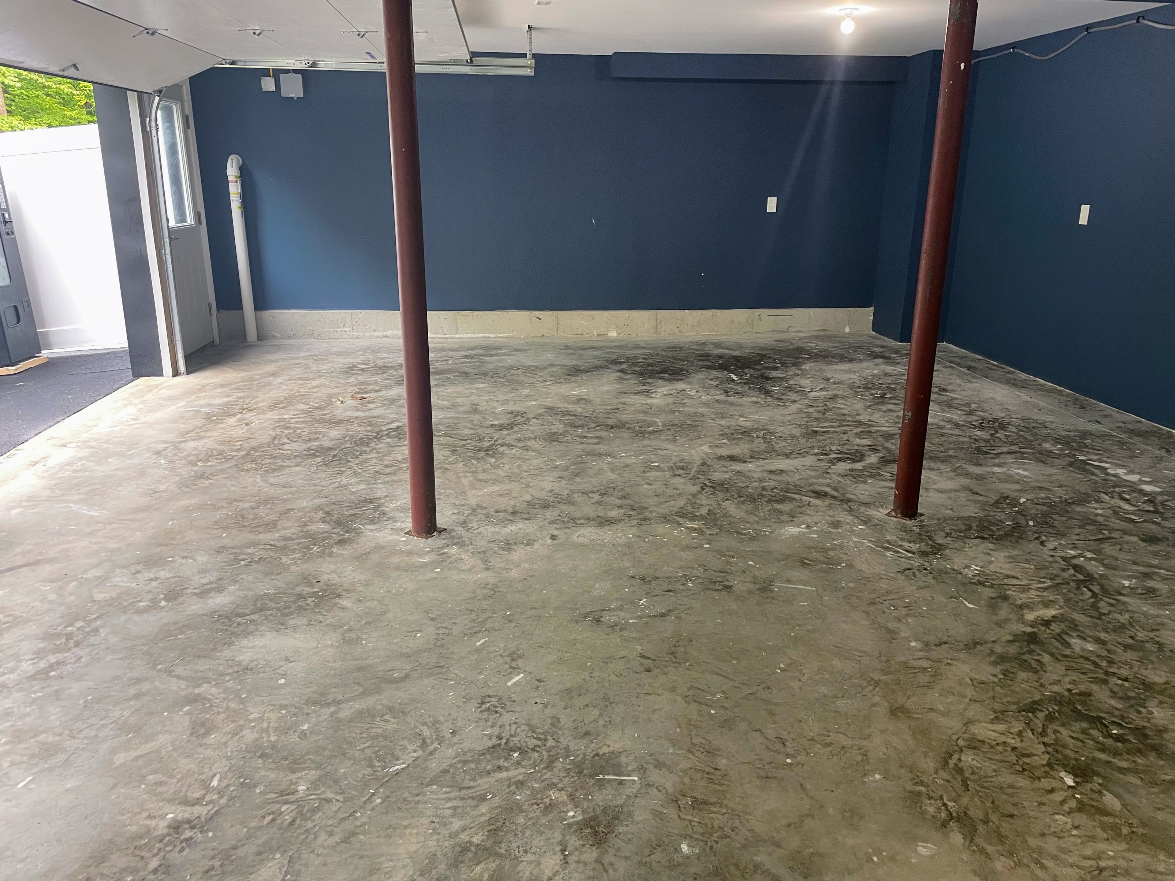 Worn and stained garage concrete around the steel support posts in Wallkill, NY