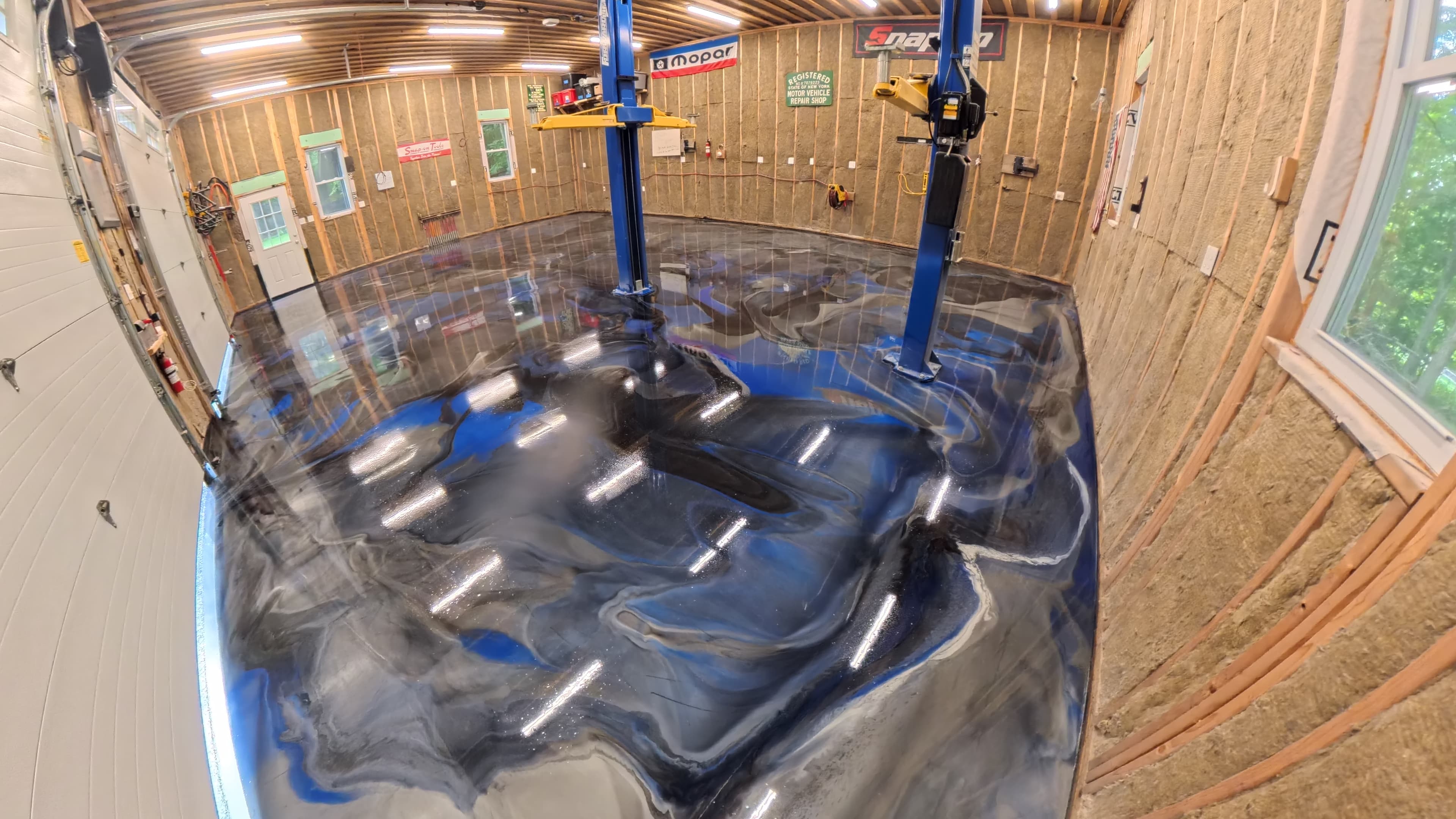 High-gloss waterfall epoxy shop floor beneath the vehicle lifts in Kerhonkson, NY