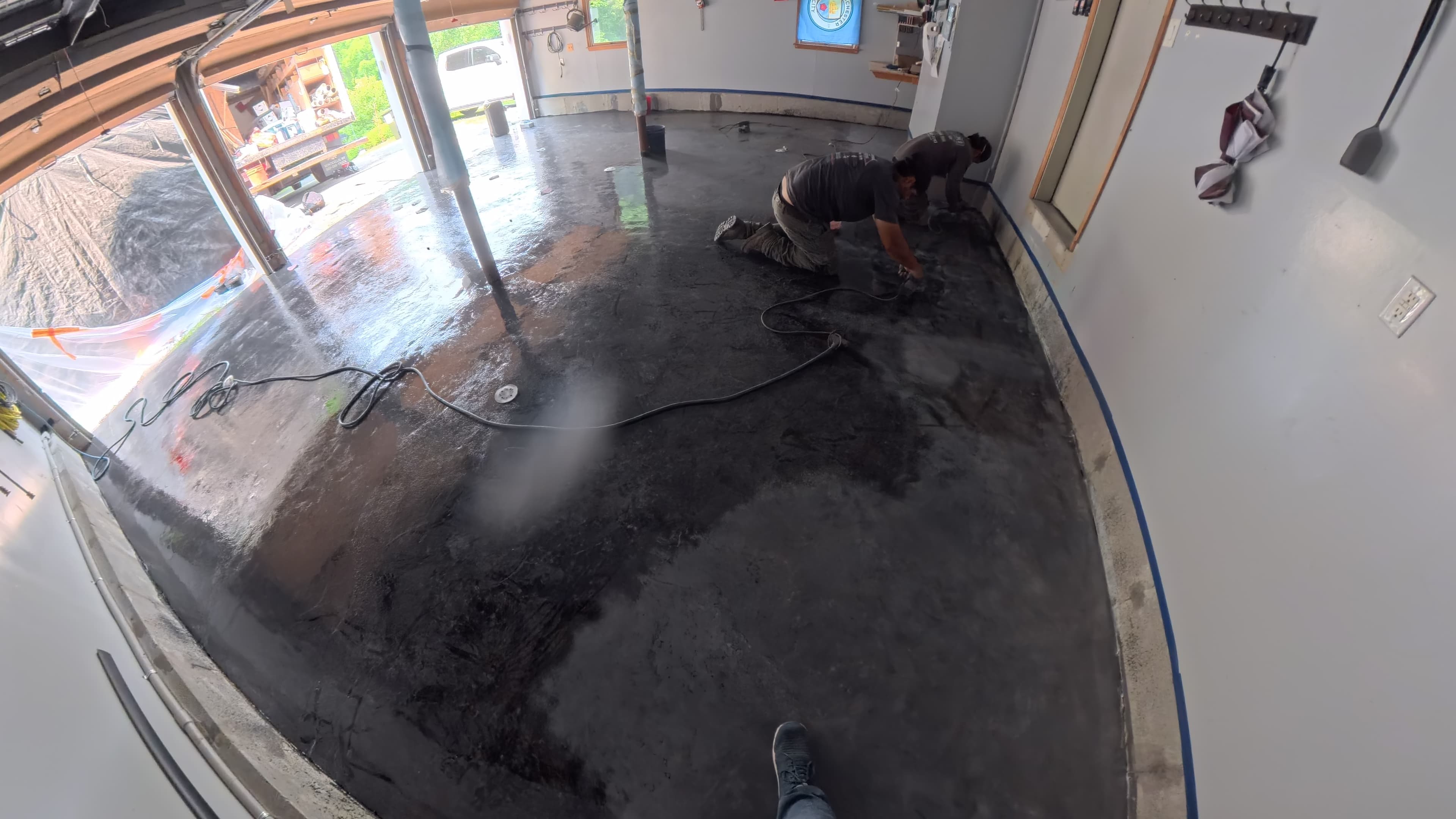 Crew patching cracks and applying a moisture vapor barrier to the garage floor in Chester, NY